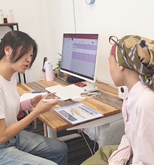 Dr Tao explaining findings using a spine chart during a patient consultation at Kirolounge